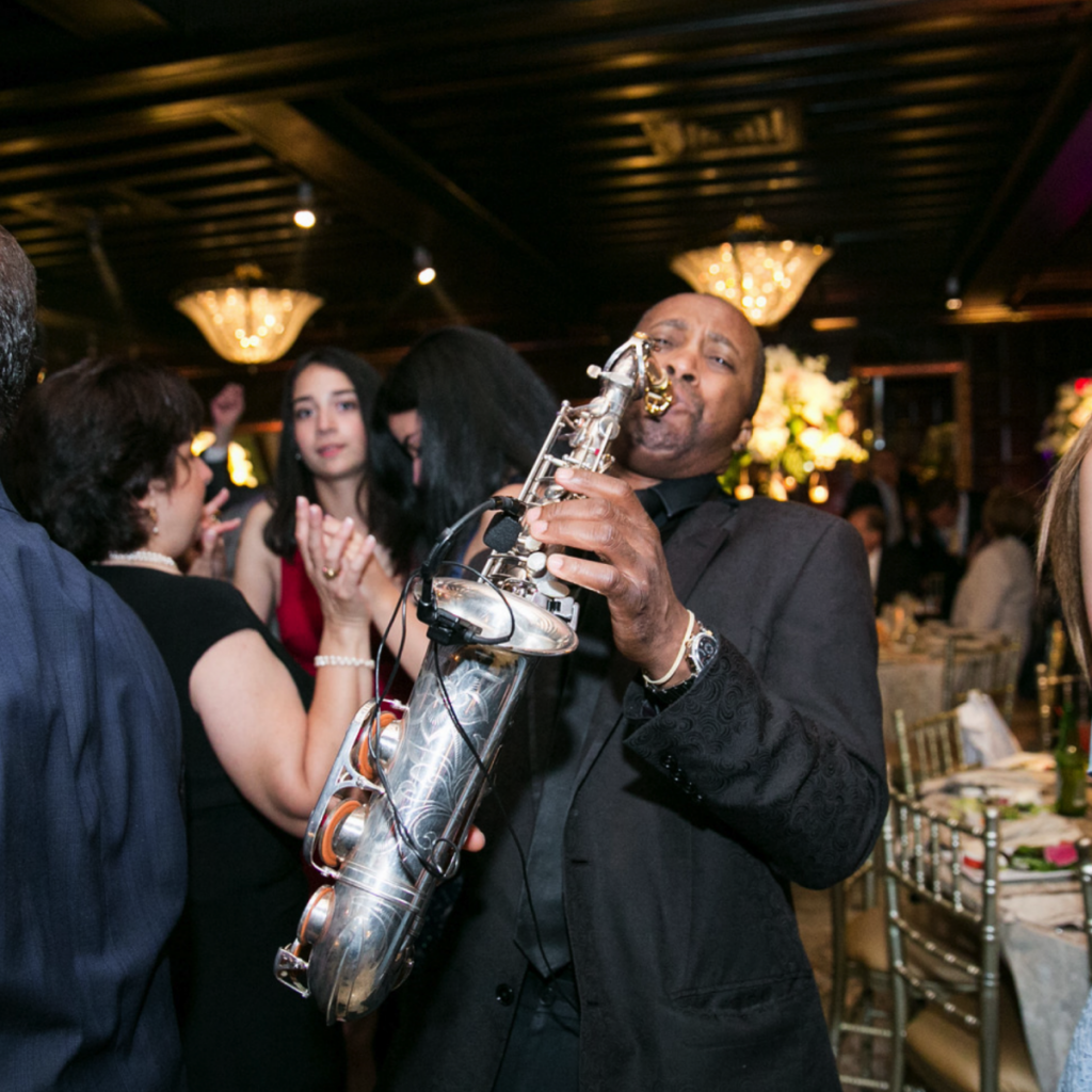 saxophonist playing and mingling with guests